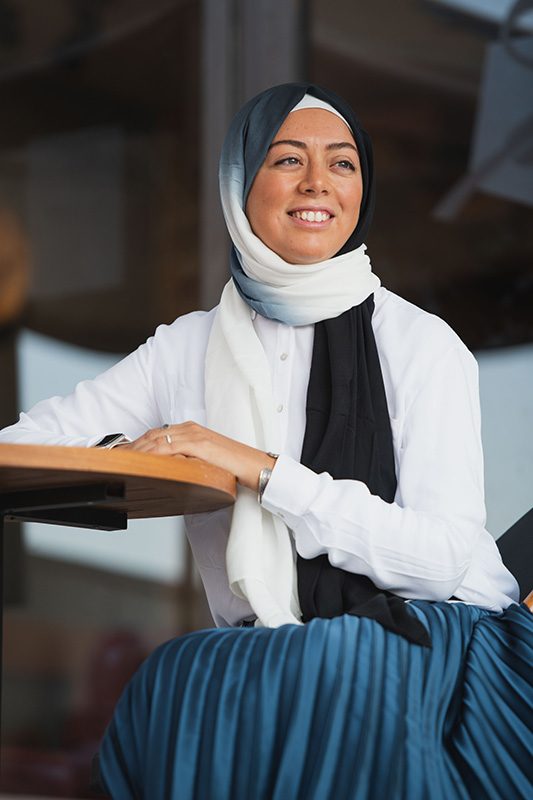 Hijabi Model wearing EMMA scarf Ebony North, in the Ombre colors of black and offwhite