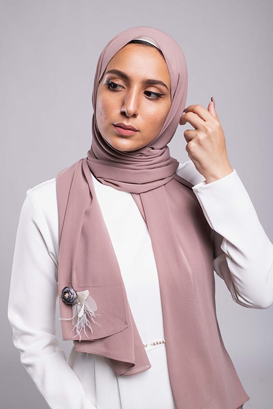 A hijabi model in EMMA Scarf Diva In mauve , with a Satin purple flower embellished on mauve chiffon