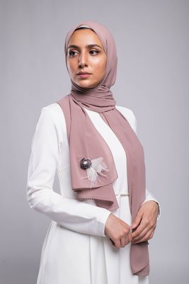 A hijabi model in EMMA Scarf Diva In mauve , with a Satin purple flower embellished on mauve chiffon