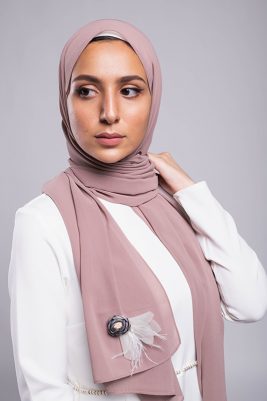 A hijabi model in EMMA Scarf Diva In mauve , with a Satin purple flower embellished on mauve chiffon