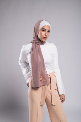 A hijabi model in EMMA Scarf Dazzle In Mauve with an embroidered sequin flower and diamond on it
