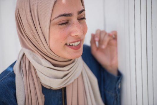 hijabi model laughing with closed eyes in EMMA Scarf Caramelised sugar