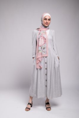full body shot of hijabi model in EMMA Scarf Honey Blooms Chiffon staring at camera, with her hand in her pocket in a grey dress