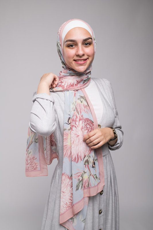 hijabi model in EMMA Scarf Honey Blooms Chiffon smiling at camera and grey dress