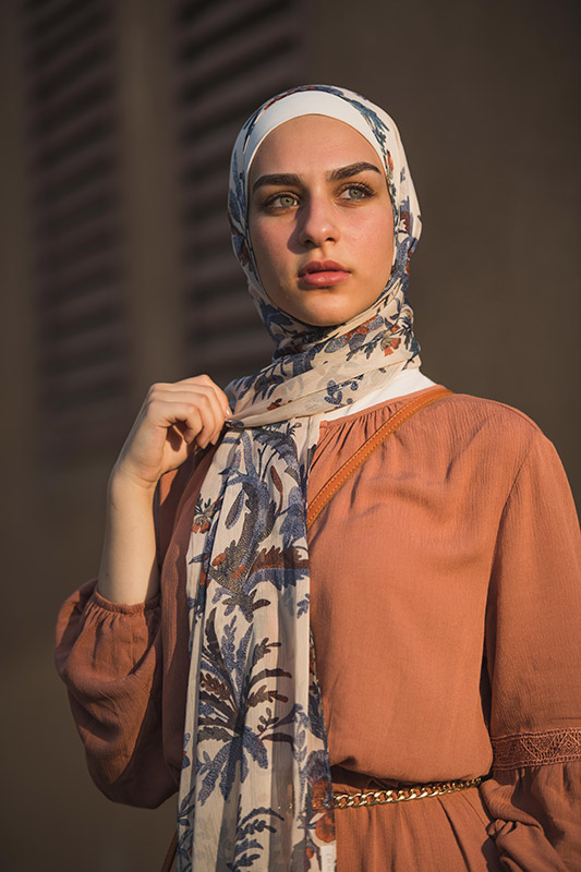 close up of white hijabi model in EMMA Scarf Camel Denim staring at distance