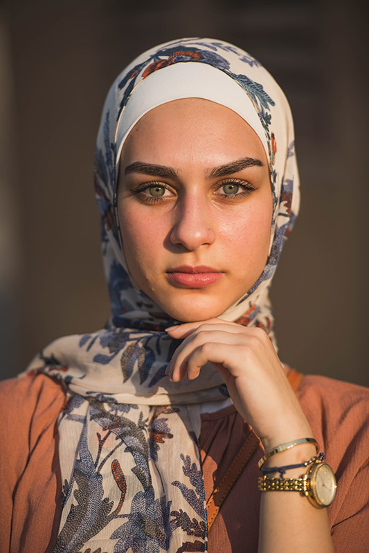 close up of white hijabi model in EMMA Scarf Camel Denim staring at camera