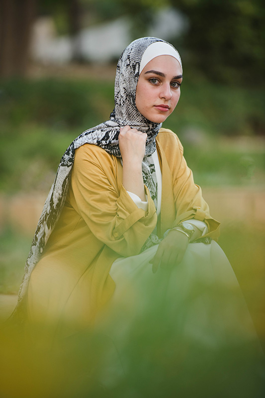 hijabi model in EMMA Scarf Black python ,sitting and staring at camera