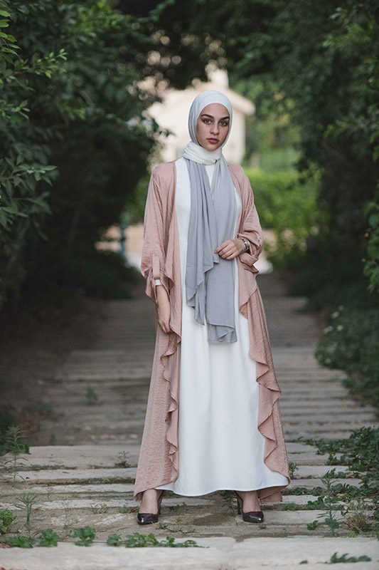 hijabi girl in a white dress, pink kimono and heels in the middle of a forest staring at the camera in EMMA Scarf