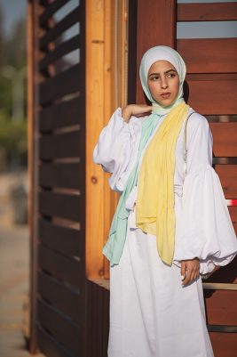 Hijabi Model in EMMA scarf Kiwi Zest featuring an ombre of yellow and light mint green in a frill sleeve white dress