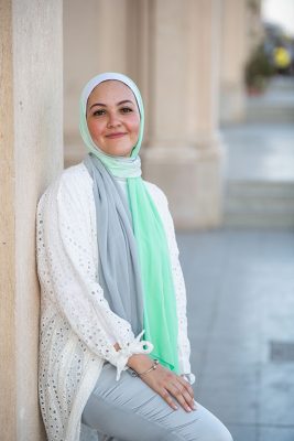 White Hijabi wearing EMMA Scarf Apple crunch and a white lace kimono, smiling
