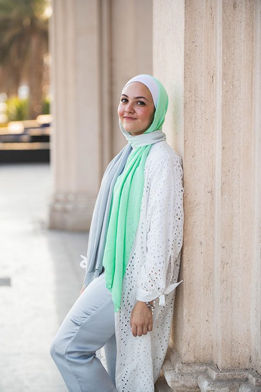 White Hijabi wearing EMMA Scarf Apple crunch and a white lace kimono