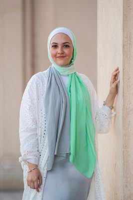 White Hijabi wearing EMMA Scarf Apple crunch and a white lace kimono