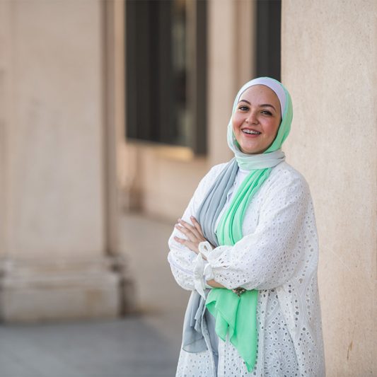 white Hijabi girl in EMMA Scarf : Apple Crunch in the colors of apple green and grey. Smiling