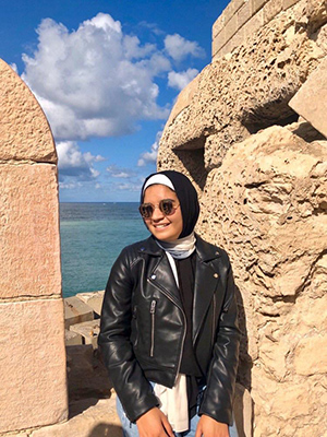 EMMA customer wearing her Ebony North hijab and a leather jacket by the beach