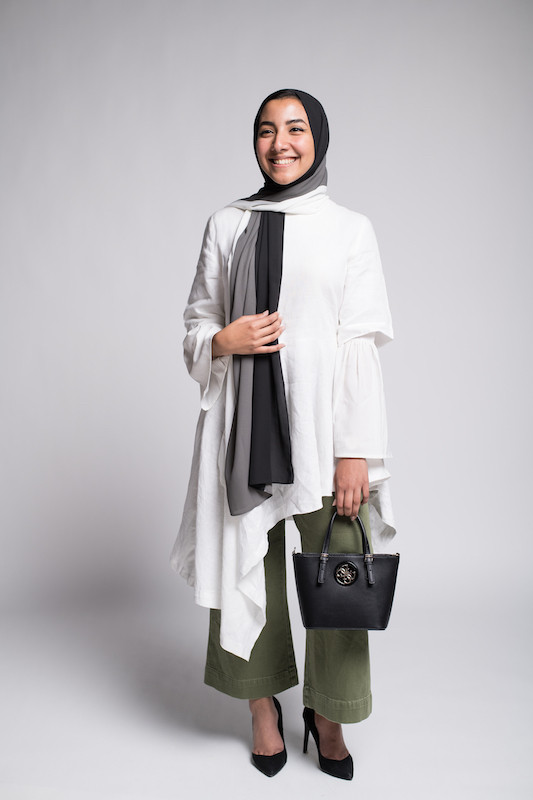 hijabi model in elegant outfit styling EMMA Scarf Licorice Cream in khaki pants, a long white shirt and a guess black bag
