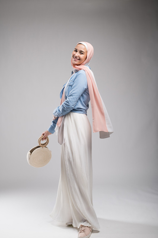 hijabi model in EMMA Scarf Peach n vanilla and a white maxi skirt, twirling while smiling at camera